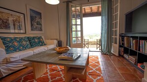 Una sala de estar acogedora con un sofá blanco, una mesa de centro con un libro y una estantería llena de libros.
