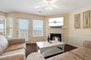A living room with a fireplace, a television mounted above it, and two sofas. - Table Rock Lake-Access Condo with Dual Kitchens, Community Outdoor Pool, Pickleball & Free Tickets (Kimberling City)
