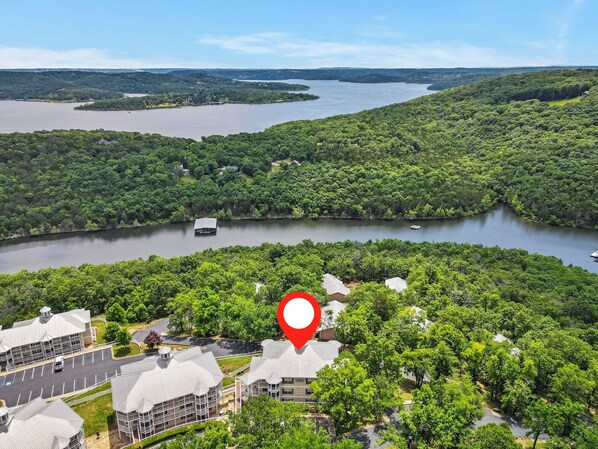 Una proprietà sul lago con un edificio grande, un pontile e un segnaposto rosso.