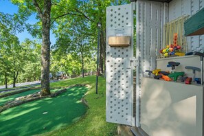 Ein Spielplatz mit Klettergerüst, Basketballkorb und einer grünen Rasenfläche.