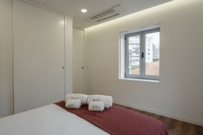 Enjoy a simple, guest-ready space with a single bed, white pillows, and a window offering a view of the outside.