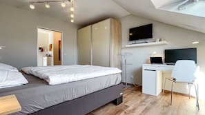 A modern bedroom with a bed, a desk, a chair, and a TV. - FeWo Siebenstern**** - 4-star vacation apartment in prime location with balcony and garage (Winterberg)