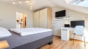 A modern bedroom with a bed, a desk, and a television. - Siebenstern**** Rental - 4-star rental with high-speed Wi-Fi, balcony & (Winterberg)