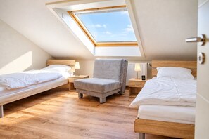 A room with two beds, a chair, and a skylight. - Siebenstern**** Vacation Rental - 4-star vacation rental with high-speed Wi-Fi, balcony & (Winterberg)