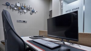 Et moderne kontor med et skrivebord, stol, computer, tastatur, mus og en dekorativ vægdekoration.