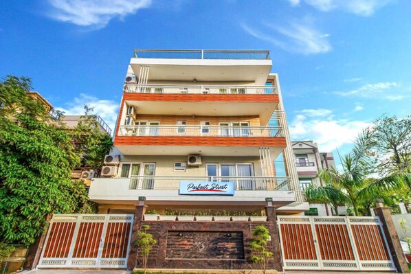 A multi-story hotel with balconies, a sign reading "Parfait Street," and a gated entrance. - Quartz -Parfait Street Near Fortis (Gurugram)