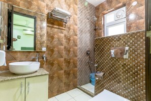 A bathroom with a marble wall, a sink, a mirror, and a shower area. - Quartz -Parfait Street Near Fortis (Gurugram)