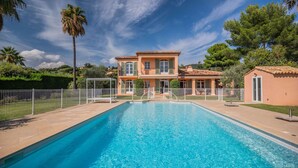 En swimmingpool med et hus i baggrunden.