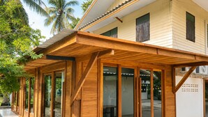 A modern building with large glass doors and wooden beams. - Punnattha House by Peema Villa (U Thong)