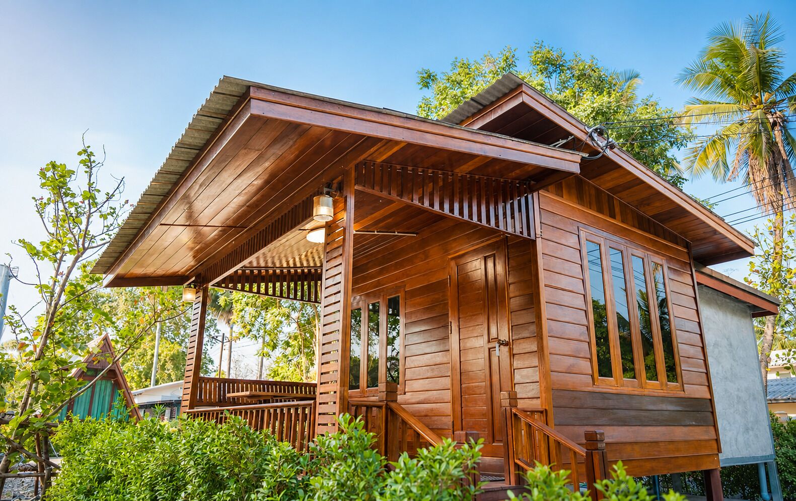 A wooden cabin with a porch, large windows, and a sloped roof.