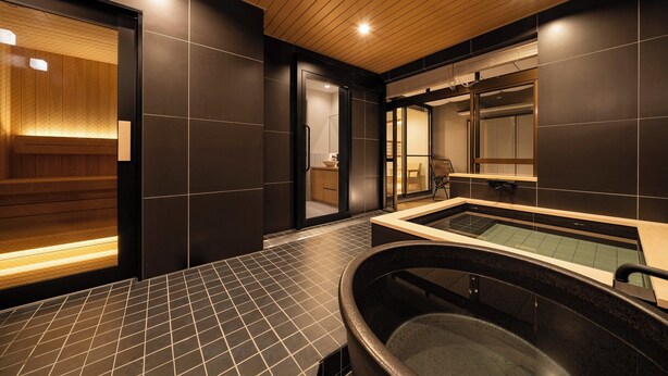Un spa moderne doté d’un plafond en bois, d’un grand jacuzzi et d’un espace sauna.