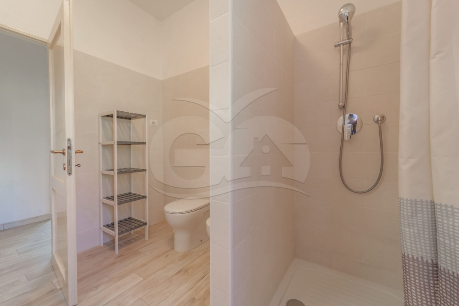 Ein Badezimmer mit Toilette, Dusche und Holzboden.