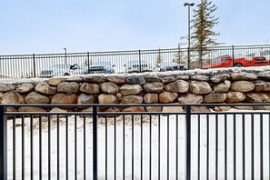 Guests can park their vehicles behind a secure metal fence surrounded by lush trees.