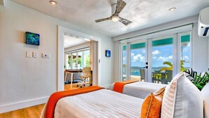 A hotel room with a large window, a ceiling fan, and a view of the ocean. - Sunset Serenity – Open Water Paradise | Dockage, Sunset Views, Dog Friendly & Minutes to Key West (Summerland Key)