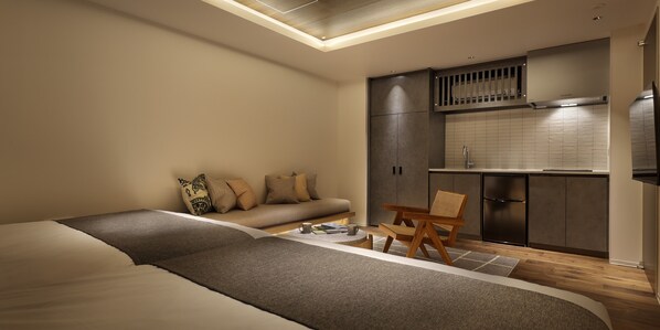 A modern bedroom with a sofa, a wooden chair, a small table, and a kitchenette. - 30 PIECES Namba (Osaka)