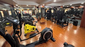 A gym with various exercise equipment, including treadmills, weight machines, and a stationary bike.
