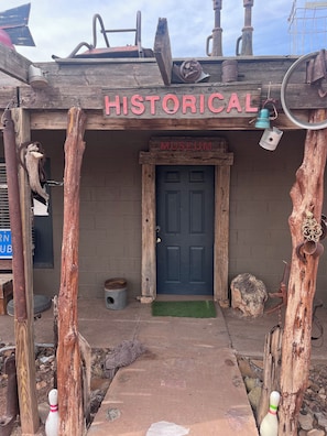 A rustic building with a sign reading 'HISTORICAL MUSEUM' and a wooden door.