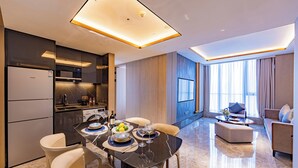 Een moderne hotelkamer met een eetgedeelte, keuken en zithoek.