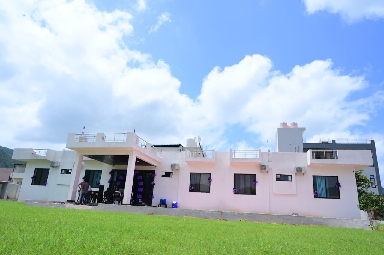 A modern two-story house with a flat roof and a balcony on the upper floor.