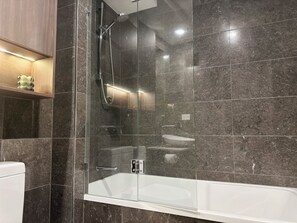 Bathroom features a glass-enclosed shower and a separate bathtub with a glass enclosure.