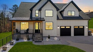 Une maison moderne à deux étages, dotée d’un porche abrité, d’un garage et d’une pelouse bien entretenue.