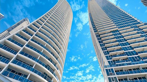 Two high-rise buildings with curved exteriors and numerous windows. - Modern 2-Bed with Pool Access in Surfers Paradise (Surfers Paradise)