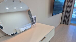 A hotel room with a large mirror, a flat-screen TV, a white desk, and a window with curtains. - Diamer Hotel Yangyang By Stayneo (Yangyang)