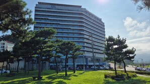 Un hôtel à plusieurs étages au design moderne, doté d’un toit plat et de grandes fenêtres.