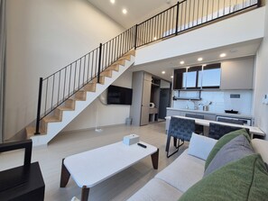 A modern apartment with a staircase, a dining area, and a kitchen. - Diamer Hotel Yangyang By Stayneo (Yangyang)