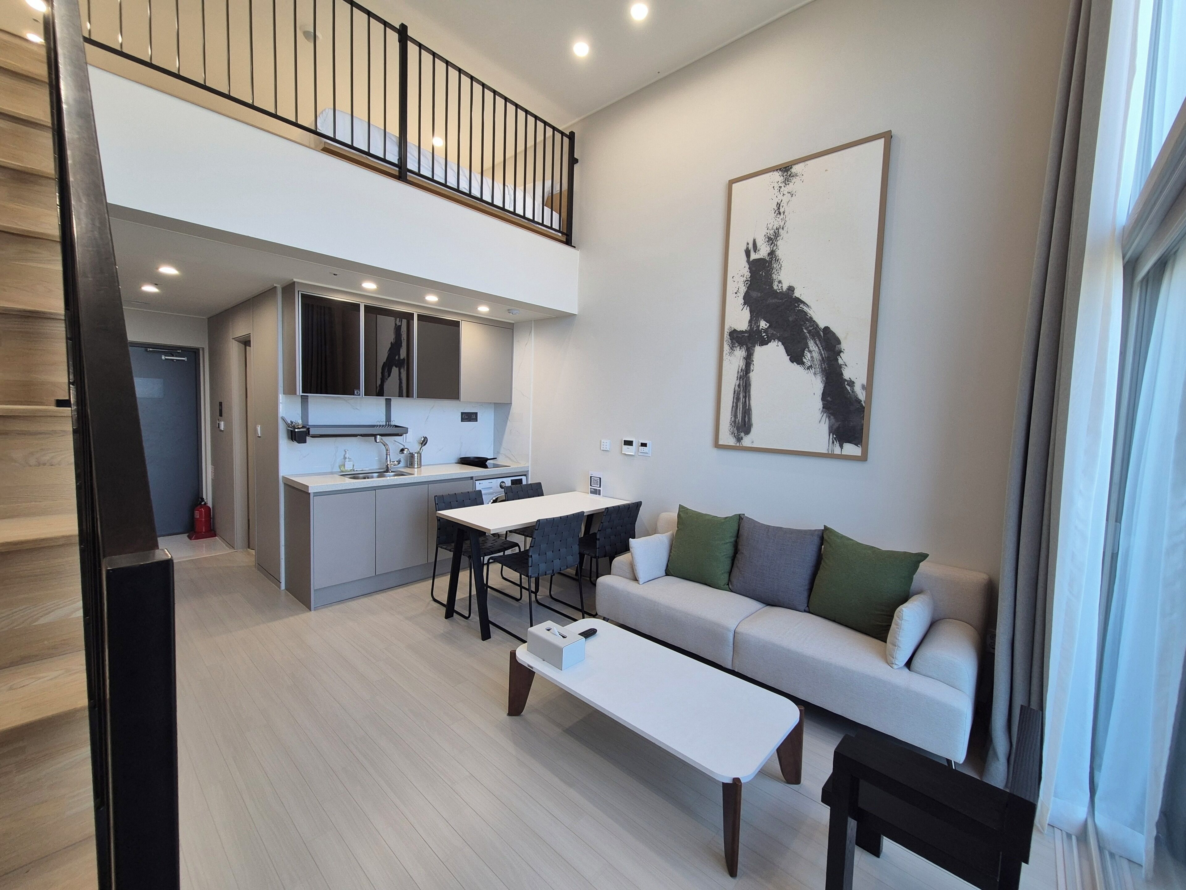 A modern apartment with a dining area, kitchen, and a living room with a sofa and a coffee table.