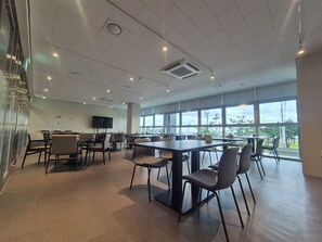 A spacious conference room with a large table and chairs, a flat-screen TV on the wall, and large windows offering a view of the outdoors. - Diamer Hotel Yangyang By Stayneo (Yangyang)