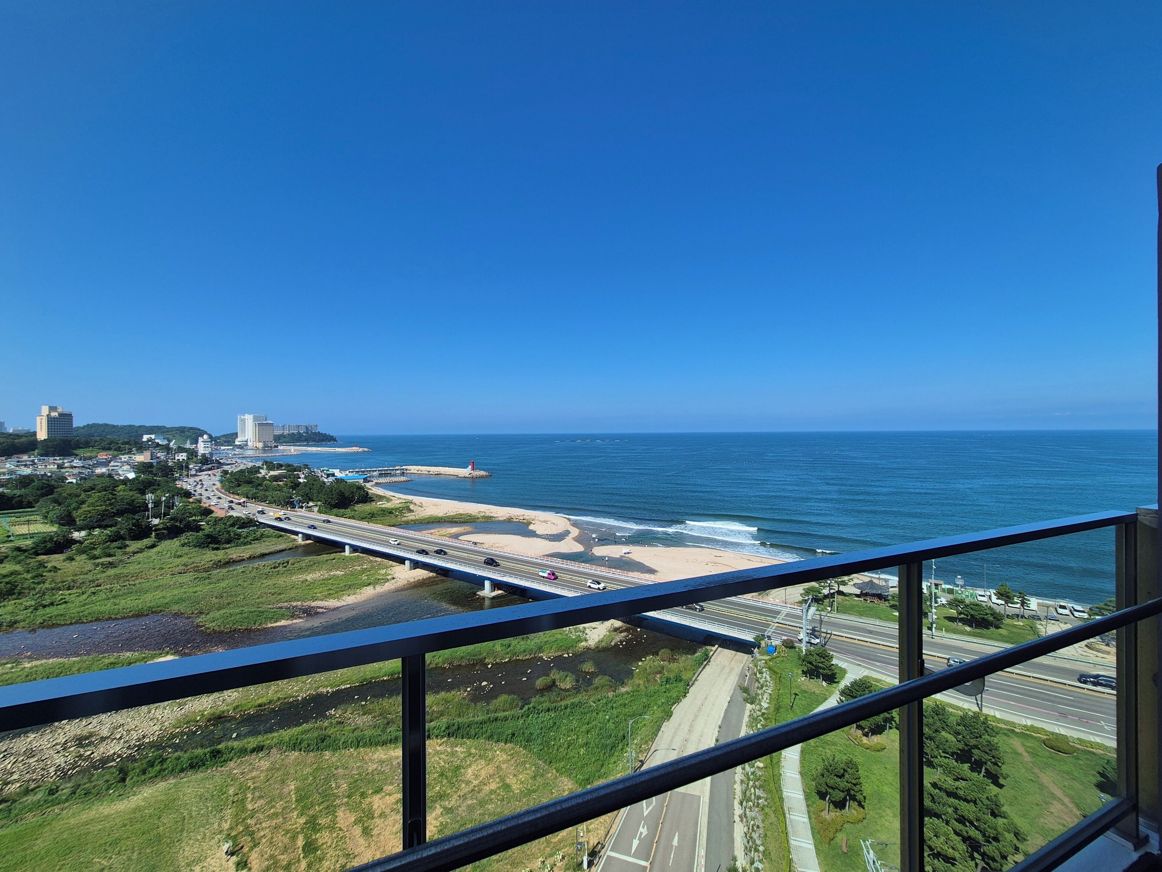 A coastal cityscape with a bridge, beach, and ocean view.