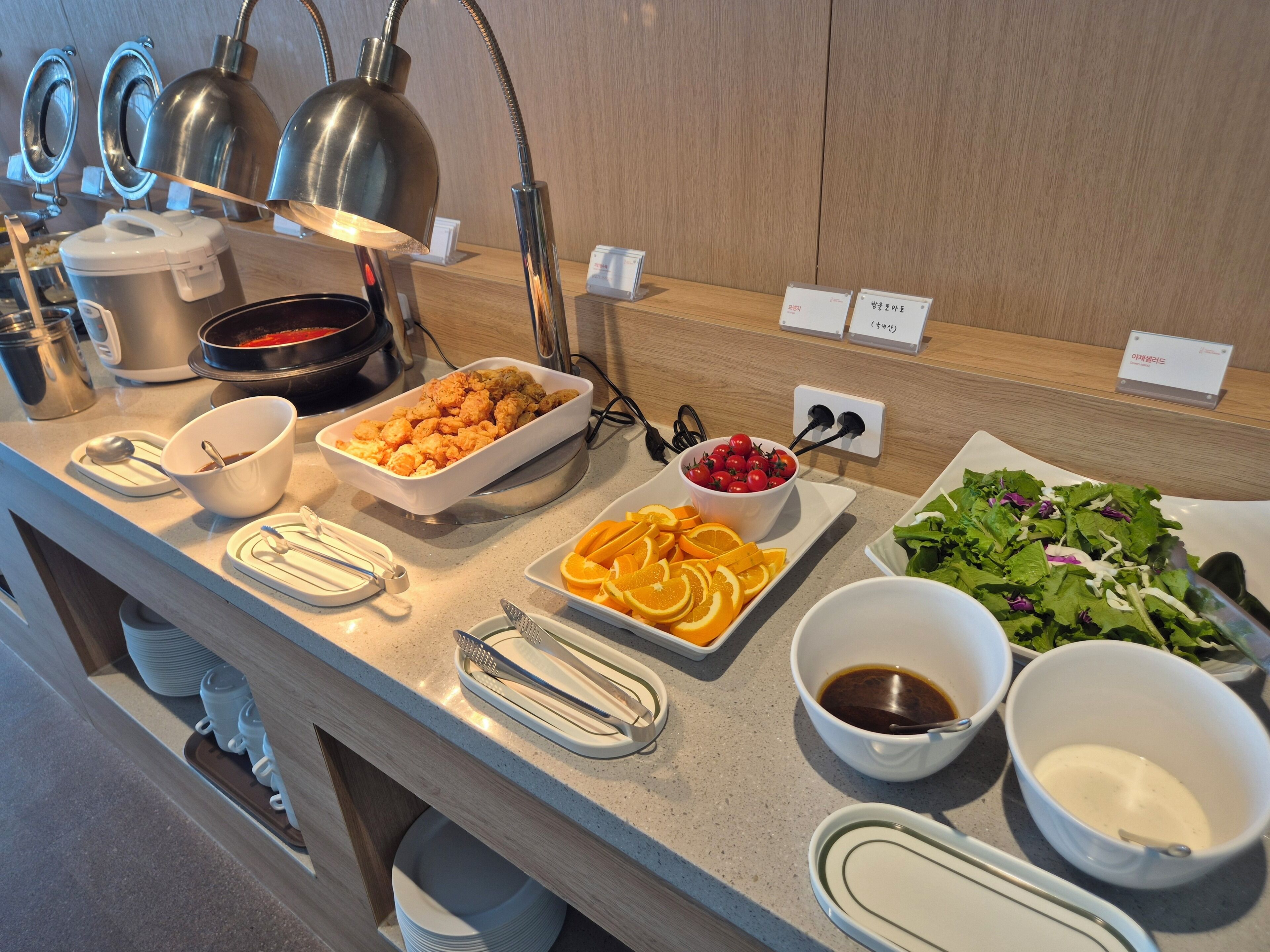 A buffet setup with various food items and condiments.