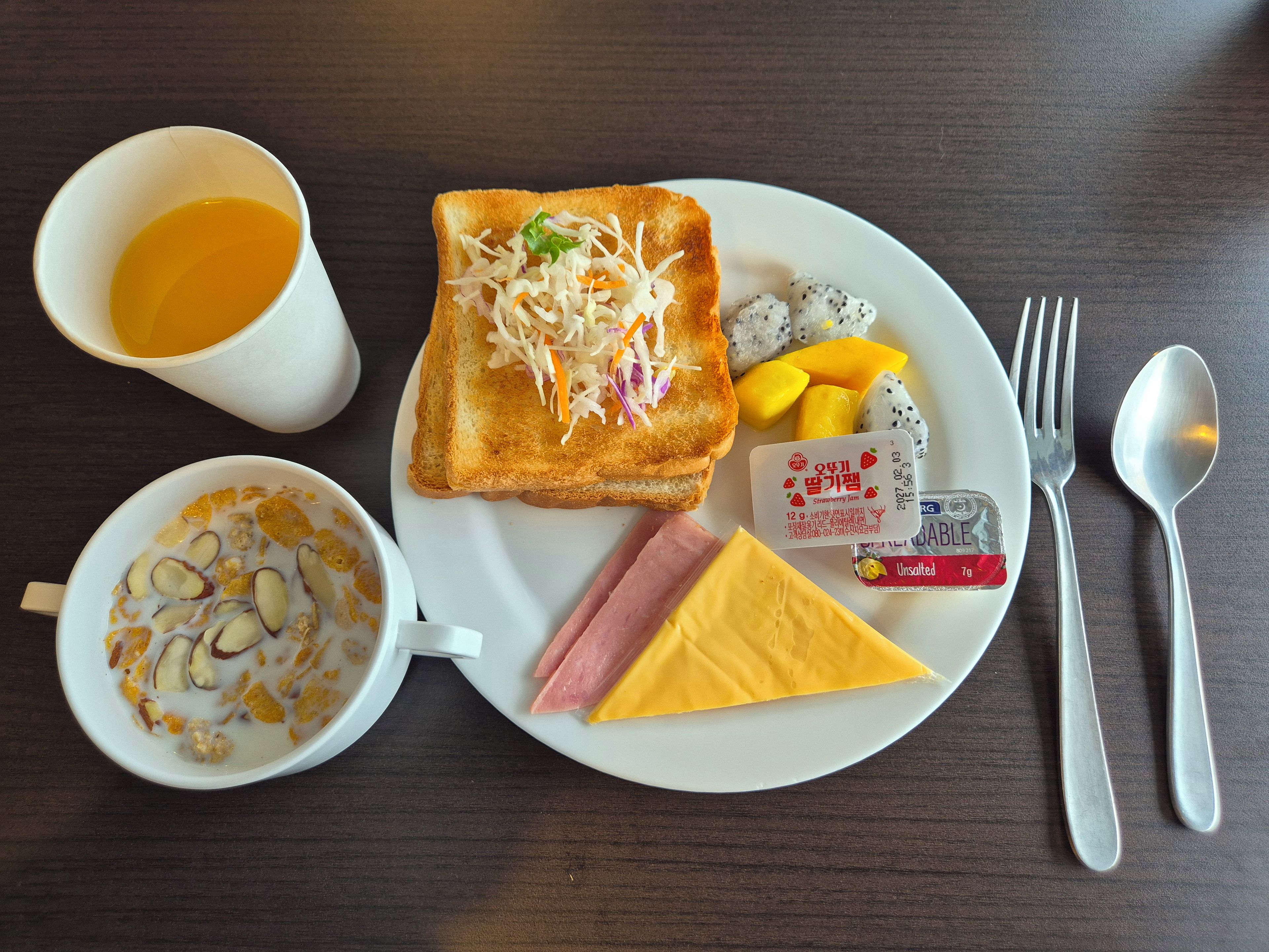 Refeição com torradas, fruta, queijo e uma xícara de café sobre uma mesa.