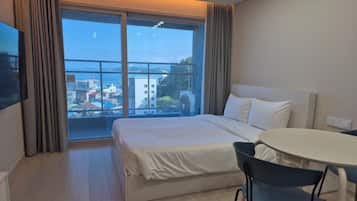 A hotel room with a bed, a round table, and a chair.