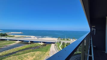 A view from a balcony overlooking a beach with a clear sky.