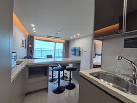 Una cocina moderna con barra, un ventanal con vistas y un lavamanos con dispensador de jabón.