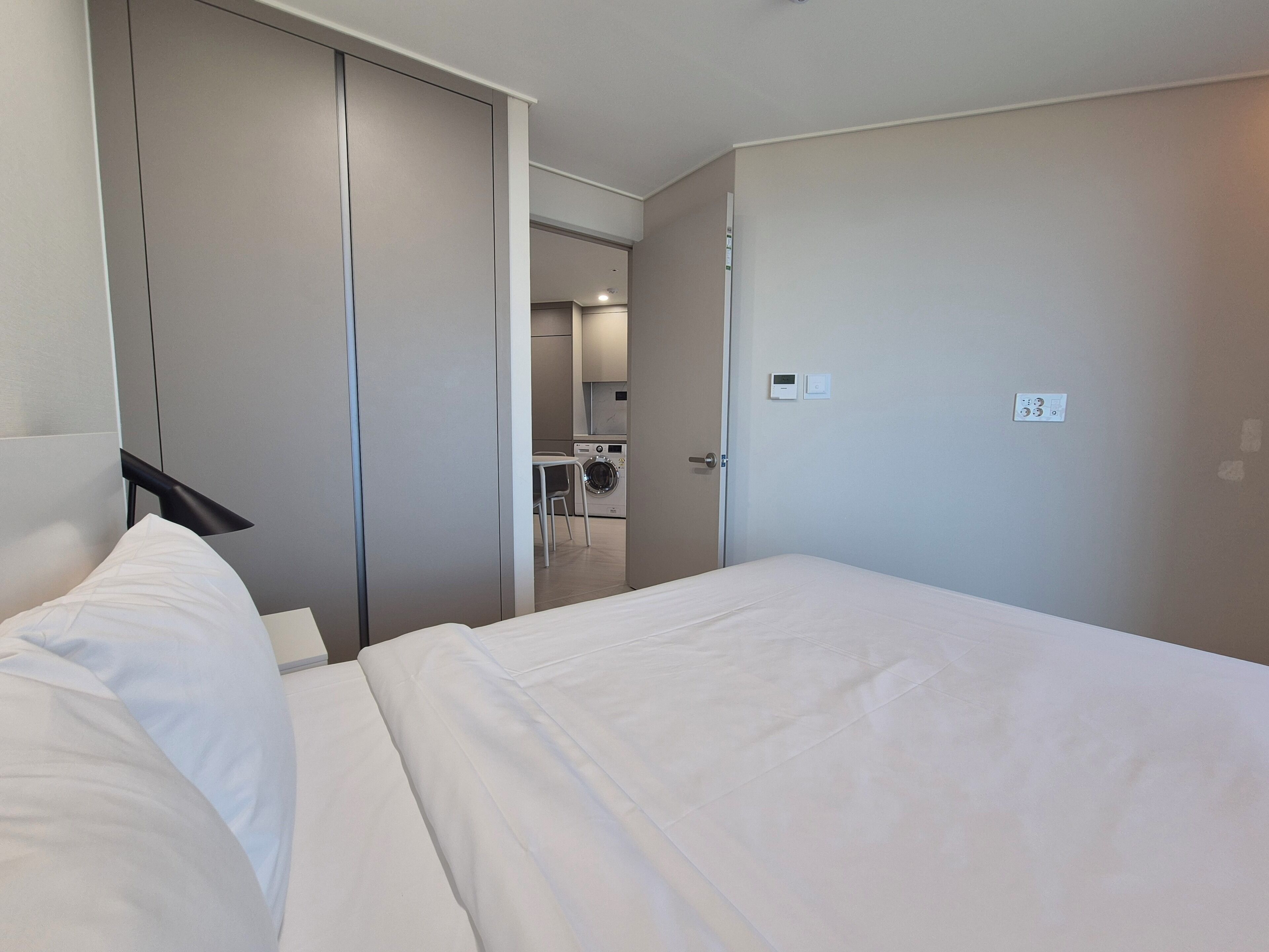 Habitación de hotel con cama, armario y pequeña cocina.