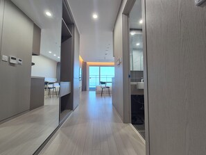 A modern hotel corridor with a wooden floor, a seating area with chairs, a desk, and a large window offering a view. - Diamer Hotel Yangyang By Stayneo (Yangyang)