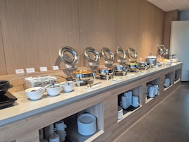 Montaje tipo buffet con múltiples estaciones de servicio, cada una con tapa y nombre indicado.