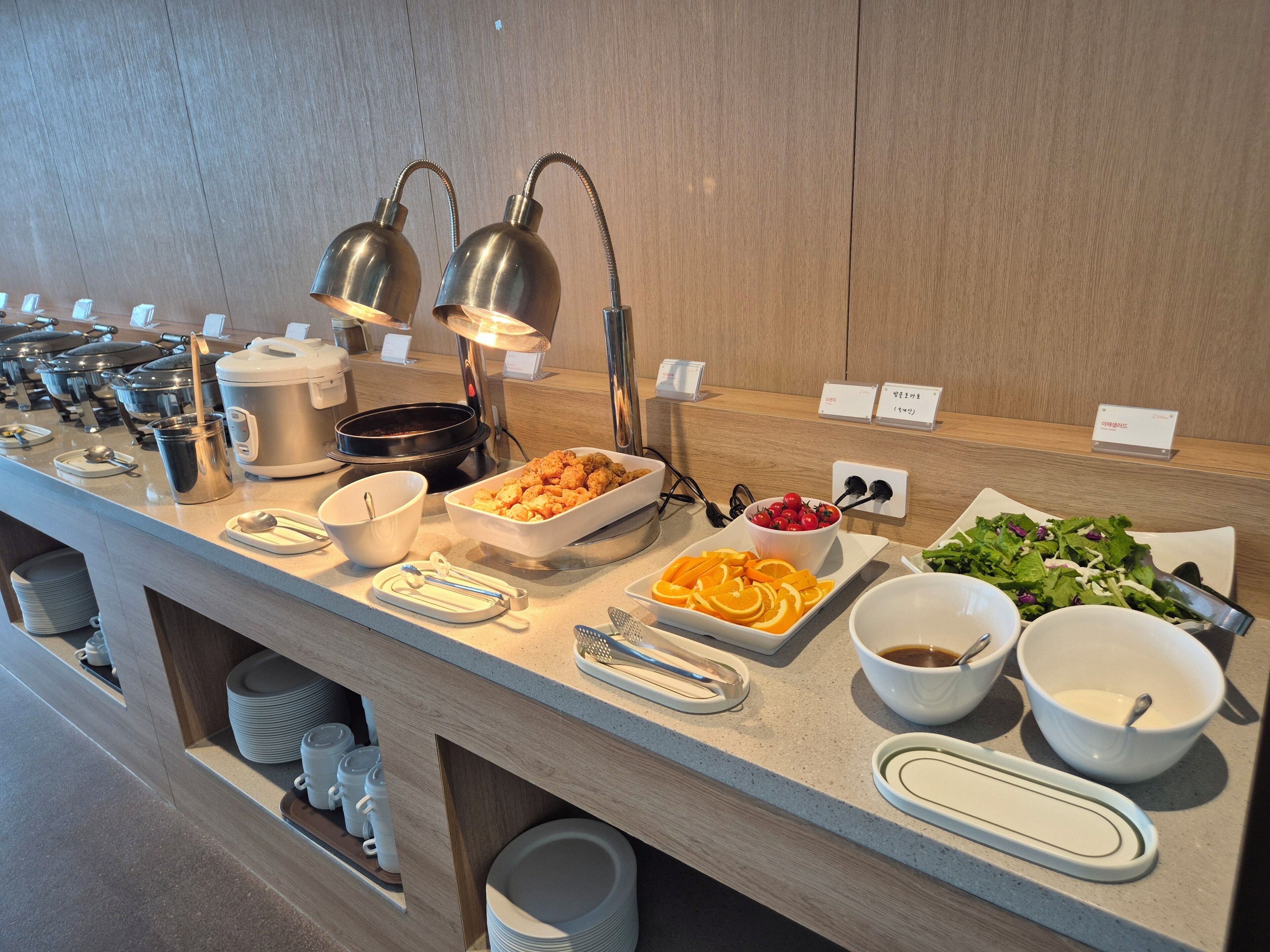 A buffet setup with various food items and utensils.