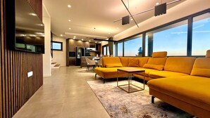 Un salon moderne avec un canapé, une table basse et un téléviseur fixé au mur.