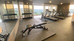Un gimnasio con cintas de correr, elípticas y una prensa de pesas.