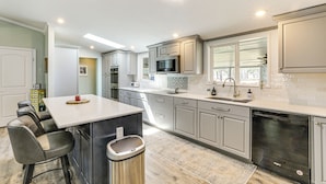 A modern kitchen with a central island, stainless steel appliances, and a view of the outdoors. - Lake Moultrie Access: Moncks Corner Home w/ Dock (Moncks Corner)