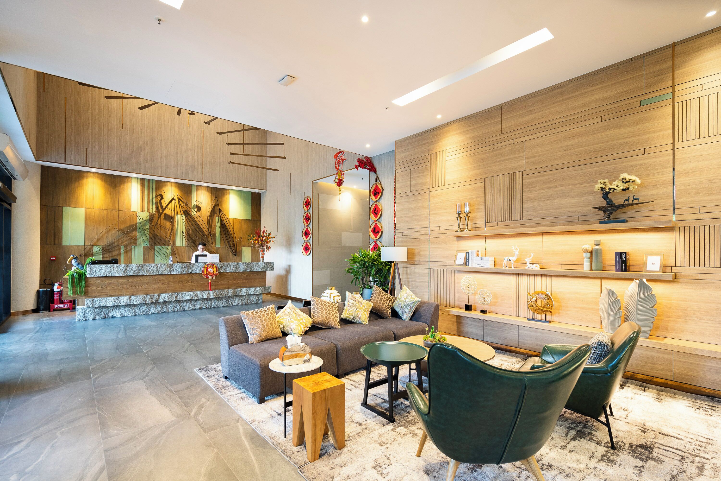 A modern lobby with a reception desk, seating area, and decorative elements.