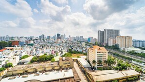 Un paysage urbain avec de hauts immeubles, une zone urbaine densément peuplée et une rivière.
