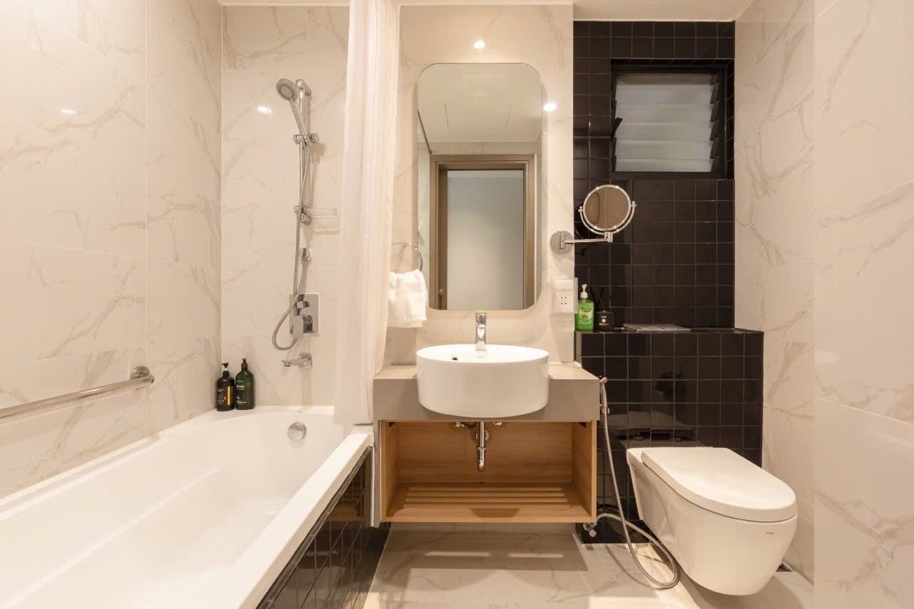A modern bathroom with a bathtub, a sink, a toilet, and a shower.