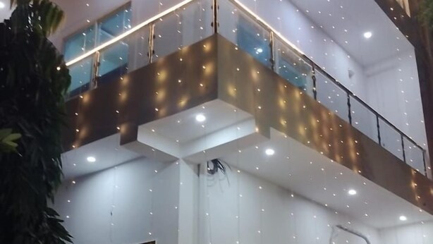 A two-story building with a balcony on the upper floor, surrounded by string lights. - Narayan Stay (Varanasi)