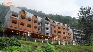 Ein mehrstöckiges Hotel mit modernem Design, mit Balkonen und einem überdachten Außenbereich.