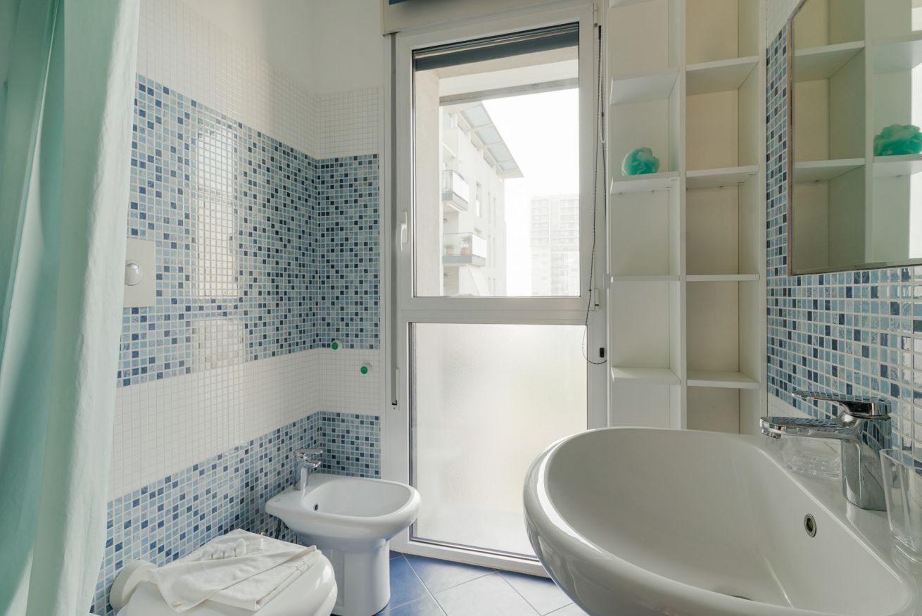 A bathroom with a white sink, a bidet, and a toilet.